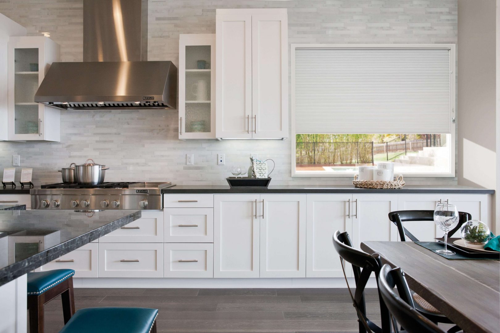 Modern kitchen featuring white honeycomb blinds on the window, complemented by white cabinetry and stainless steel appliances
