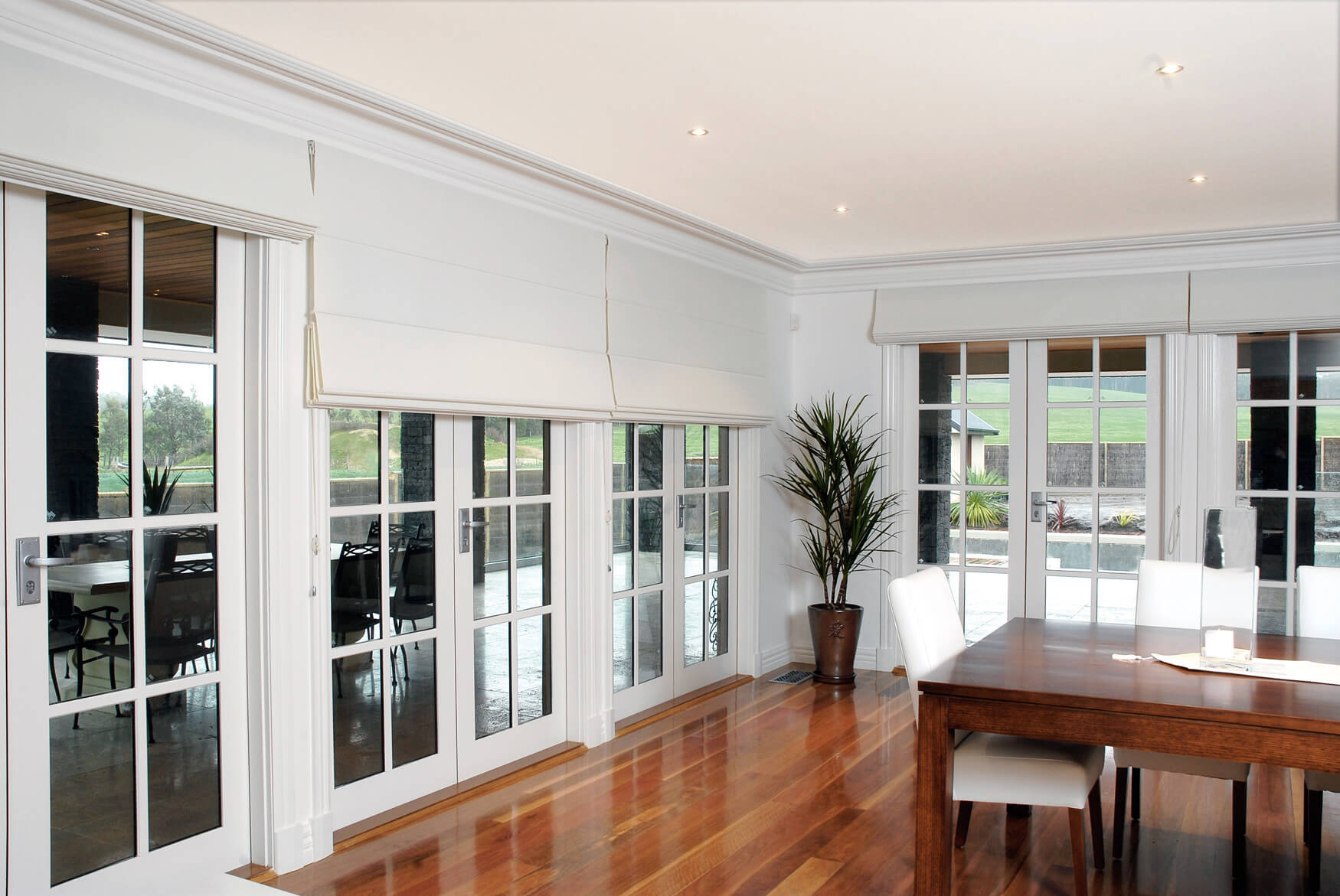 Multiple-blockout-roman-blinds-in-a-neutral-living-room-with-wooden-floor-central-table