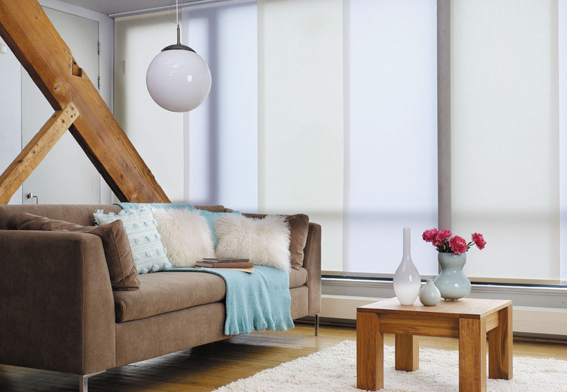 Blue and green panel blinds in a modern living room with timber features and a brown couch