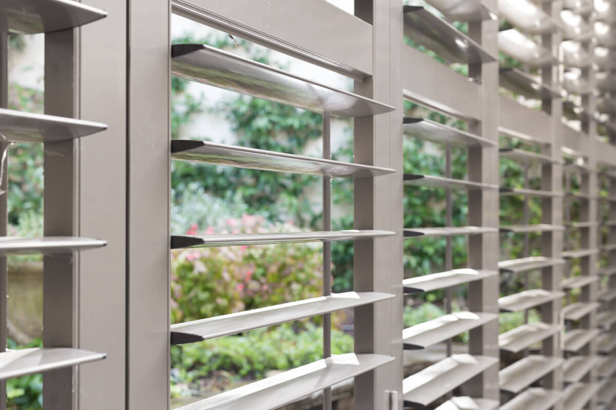 Close up of aluminium shutters open to the garden 