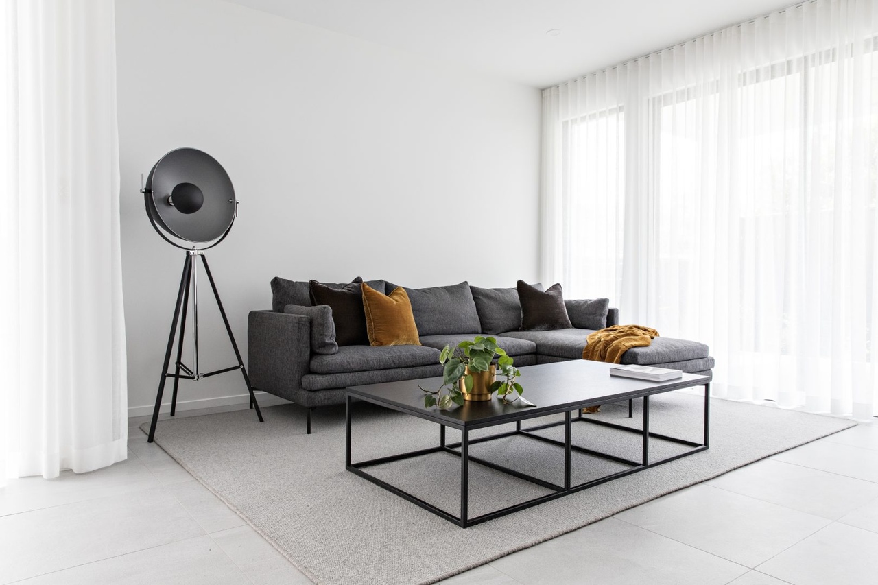 contemporary living room with grey couch black lamp white sheer curtain